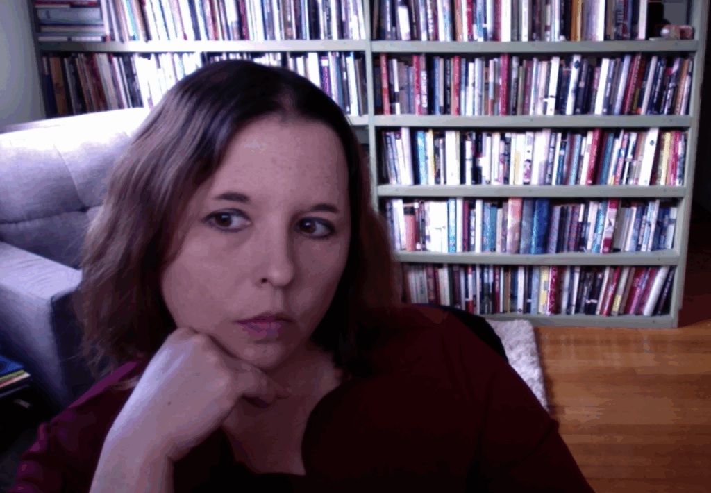 Photo of Erin Elizabeth Smith, a white woman with brown hair, with her head on her hand in front of a bookshelf.