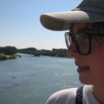 Rachel Bulman looks left over the wide, blue Gard-Vaucluse river on a bright summer afternoon.