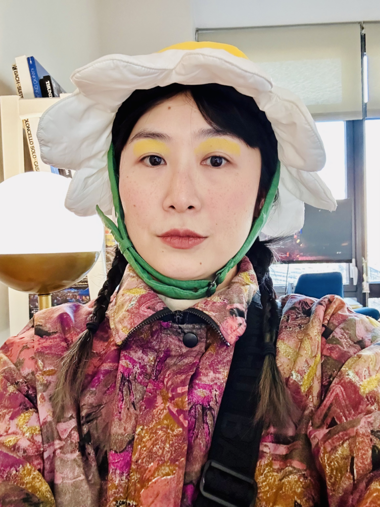 A photo of Stine An wearing a flower hat.