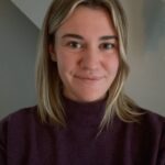 A photograph of Molly Hoyer, a white woman with blond hair wearing a brown sweater