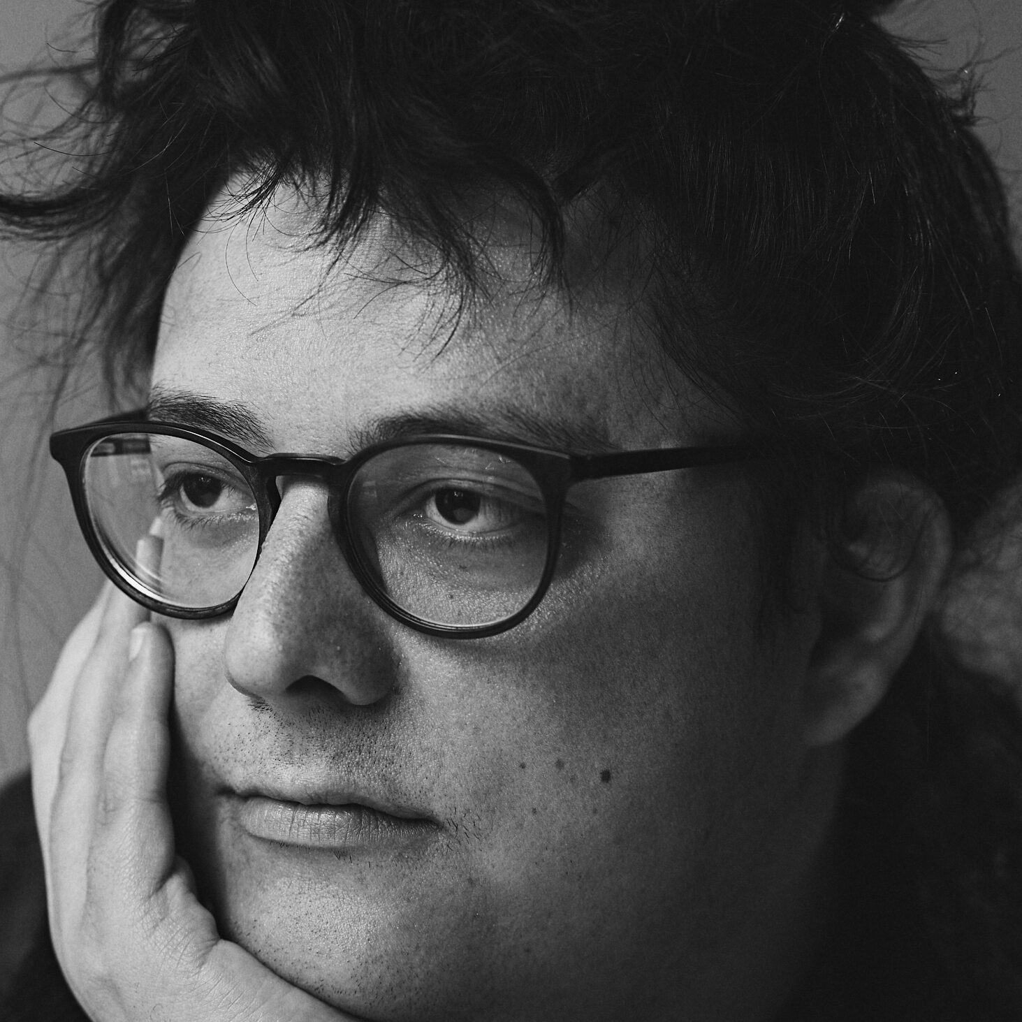 Black and white photo of author with dark glasses and hair