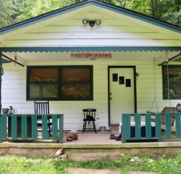 Front porch of the Firefly Farms farmhouse in the summertime.