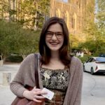 Photograph of Caroline Webster standing in front of a brick building