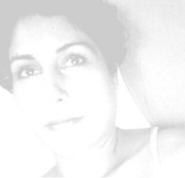 Black and white photo of Moni Brar. She has short, black, curly hair and is looking up and slightly to the right.