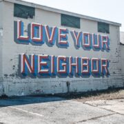 The phrase "Love Your Neighbor" painted on the side of a building