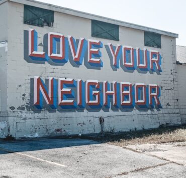 The phrase "Love Your Neighbor" painted on the side of a building