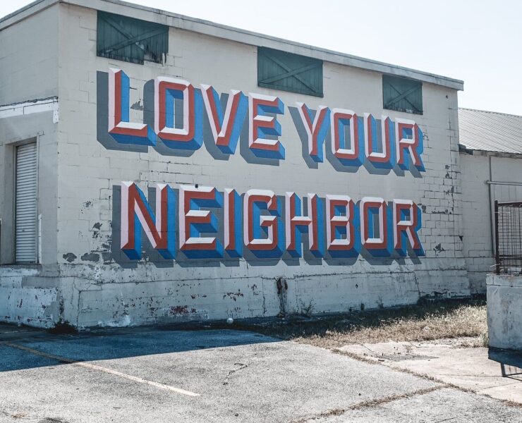The phrase "Love Your Neighbor" painted on the side of a building
