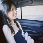 Girl with dress sitting in a car.