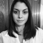 A black and white photo of Amanda Scott with brunette, shoulder-length hair, wearing a white blouse.
