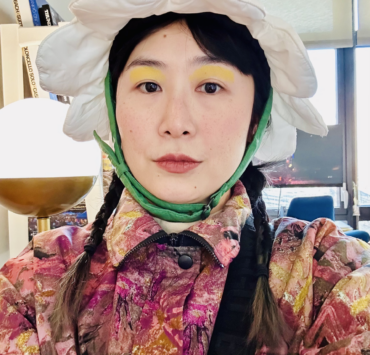 A photo of Stine An wearing a flower hat.